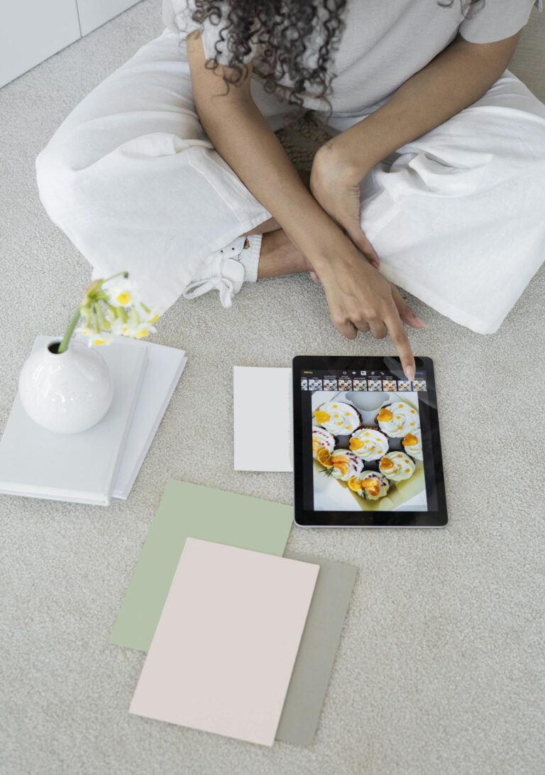 Young woman using a tablet in a modern, minimalist workspace with pastel decor.